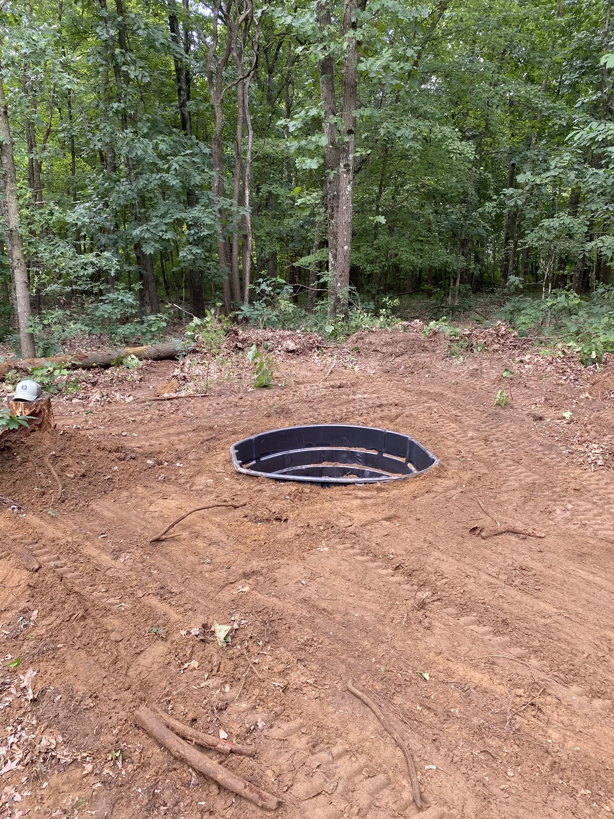 300-gallon wildlife water tank set flush in the ground at the edge of the woods